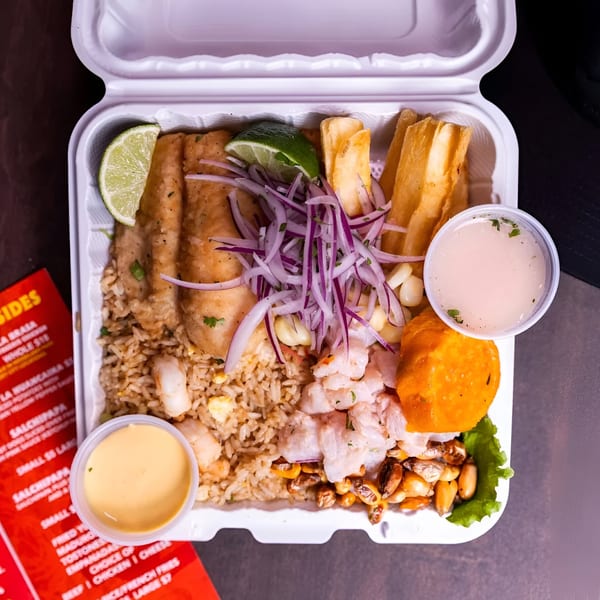 Peruvian Lomo Truck takeout container with fried fish, rice, ceviche, yuca fries, and sauces.