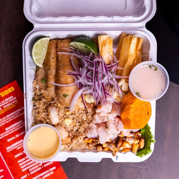Peruvian Lomo Truck takeout container with fried fish, rice, ceviche, yucca fries, and sauces.