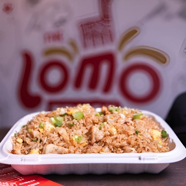 Peruvian fried rice with chicken, egg, and green onions in a white takeout container from Lomo Truck.